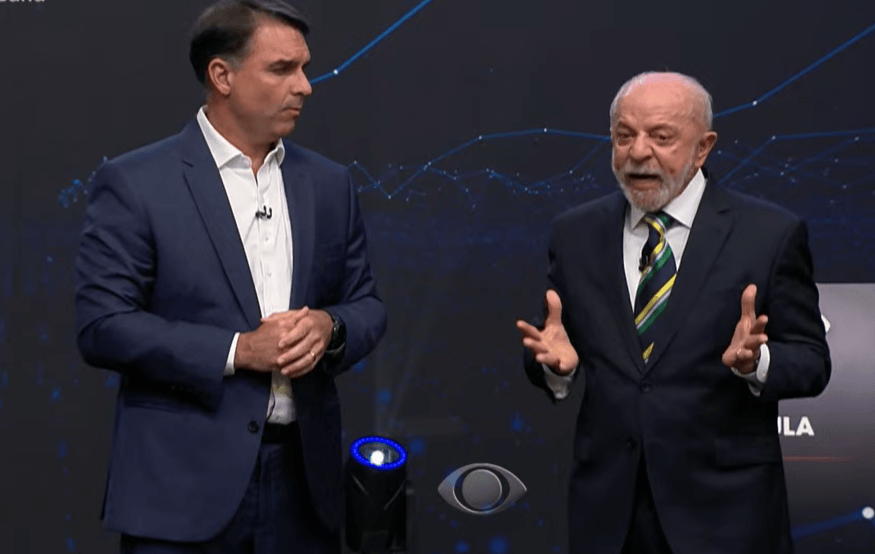 DEBATE: Lula cobra Flávio sobre Covid e filho de Bolsonaro admite falha, mas cita "pandemia de assassinatos"
