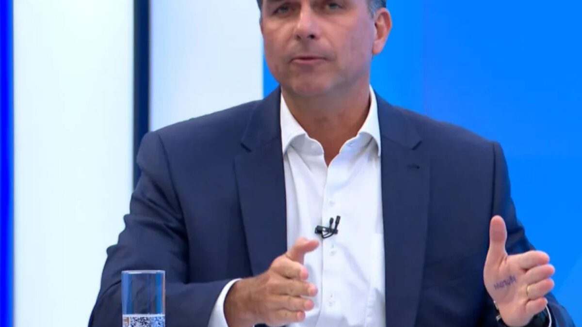 Flávio Bolsonaro escreve "motoboy" na palma da mão durante sabatina na TV Globo